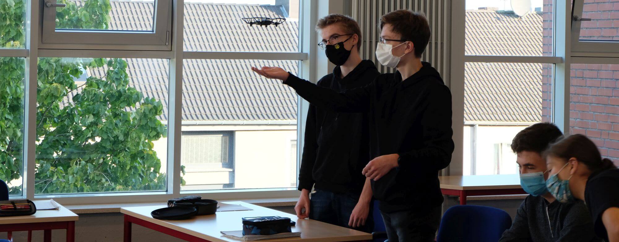 Zwei Teilnehmer mit fliegender Drohne bei einem Drohnen-Workshop